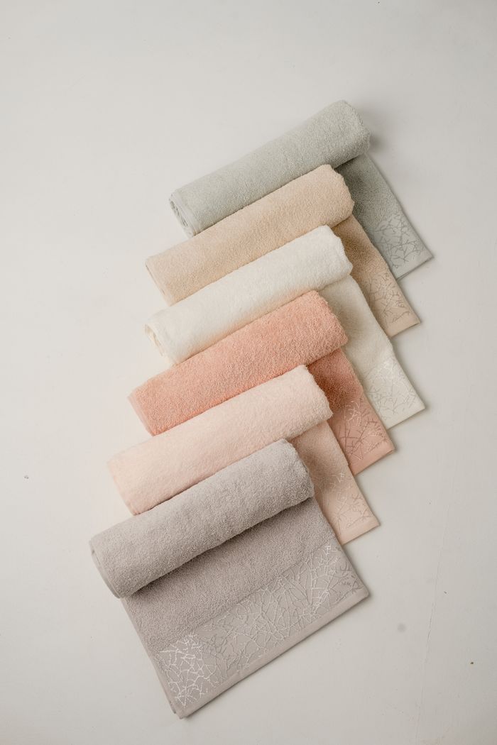 brand-01 Aesthetic display of pastel towels elegantly arranged on a white background.