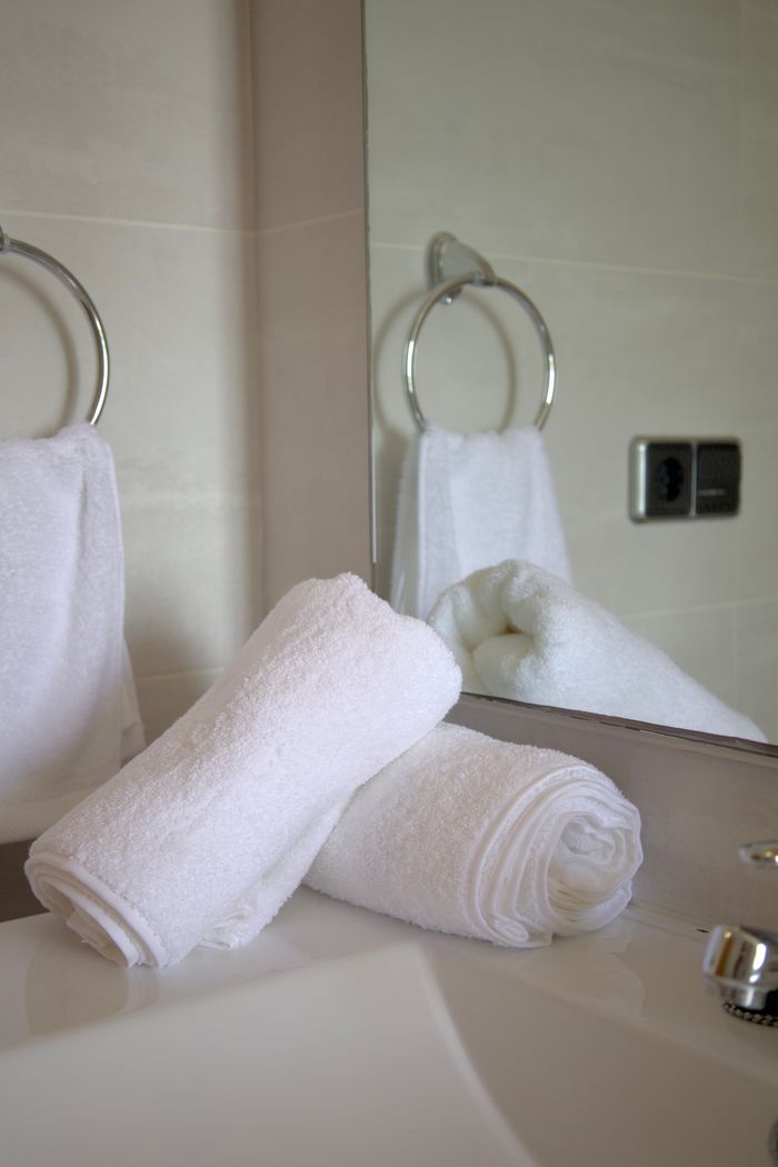 mobile-02 Pristine white towels neatly arranged in a stylish bathroom setting.