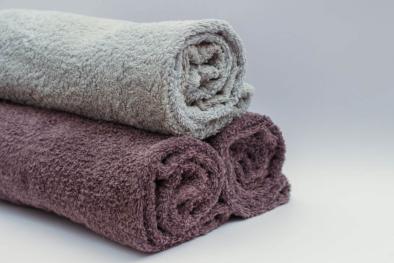 brand-02 Close-up of rolled bathroom towels in neutral tones, ideal for interior design or spa themes.