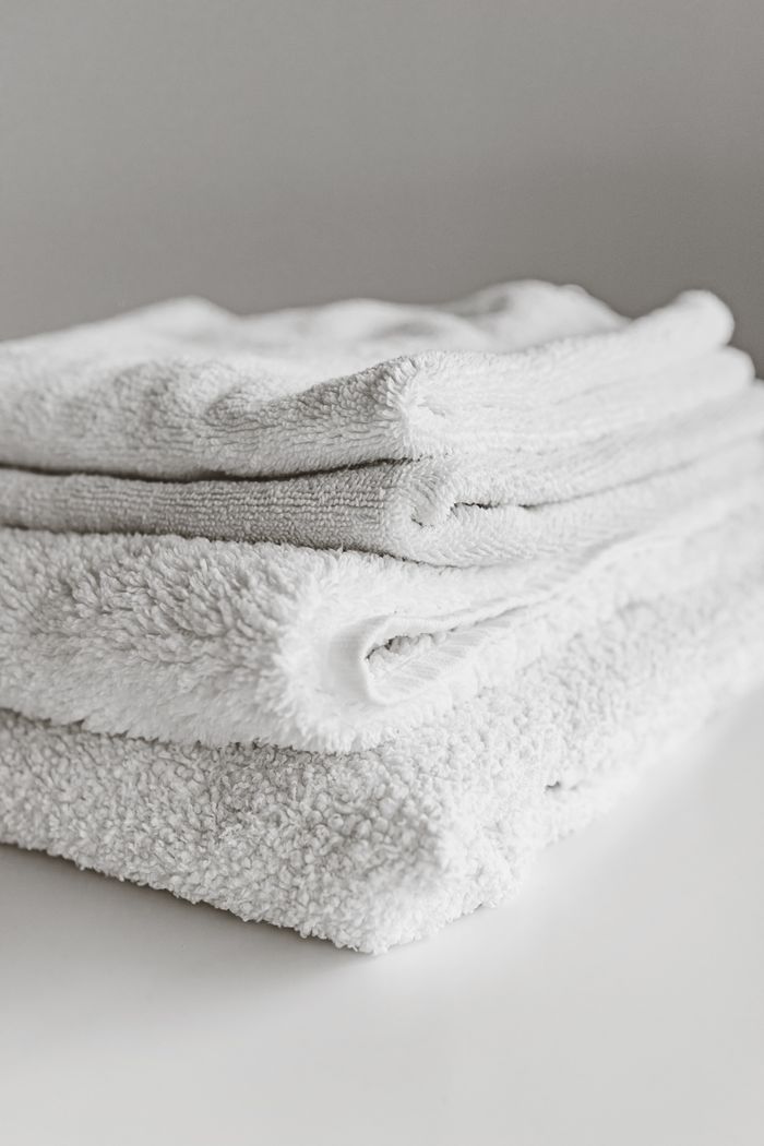 creative-02 Neatly folded clean white towels stacked on a surface, perfect for home or spa use.
